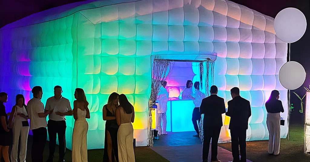 Une boîte de nuit gonflable PopUp Club installée dans une soirée privée avec les invités et le mobilier lumineux à l'intérieur