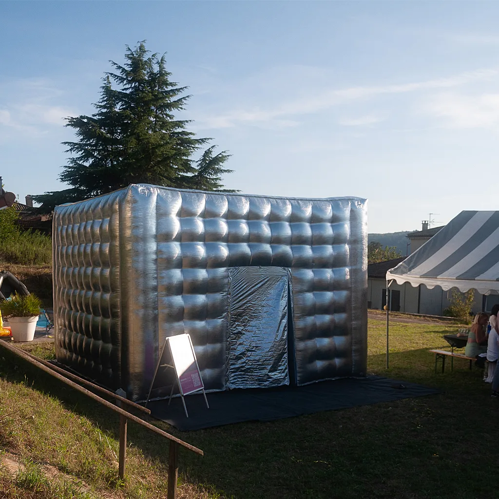boite de nuit gonflable à louer dans une jardin avec piscine pour une fête avec des invités qui diner sous une chapiteau