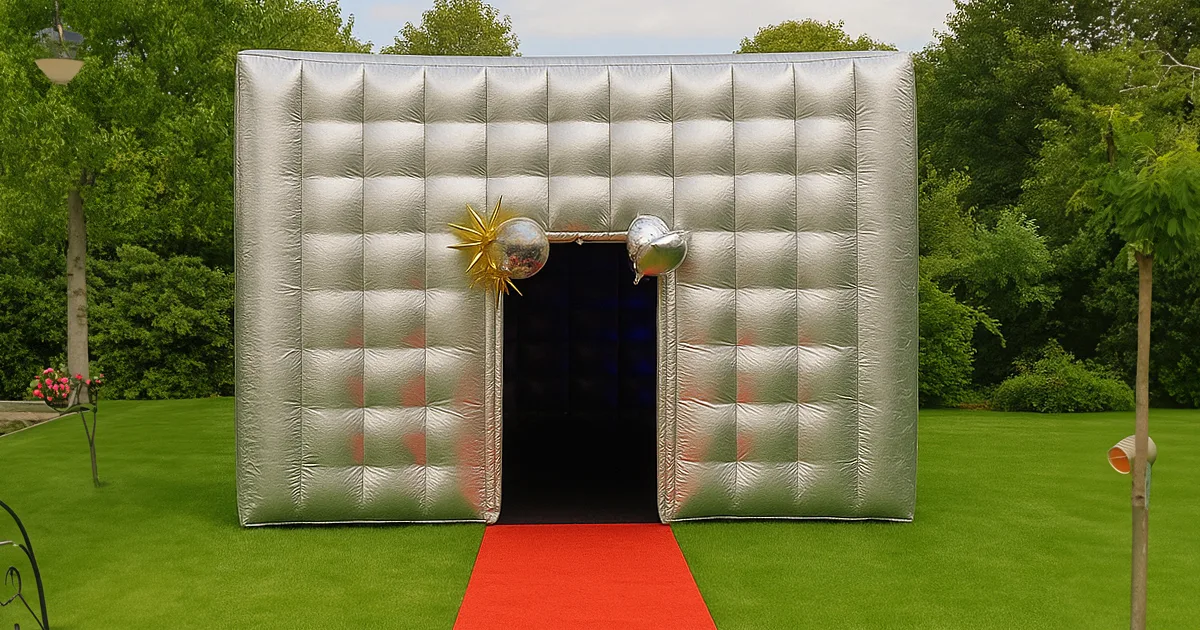 Notre boîte de nuit gonflable 5x5m installée sur une pelouse dans un jardin avec un tapis rouge à l'entrée.